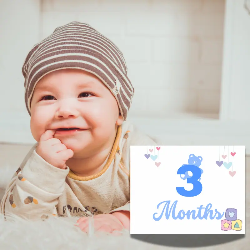 A baby milestone card leaning against a baby laying on his tummy. The sign says 3 months in complimentary shades of blue and features a light blue teddy bear peaking out from the number 3 and 3 soft colored blocks in the corner.