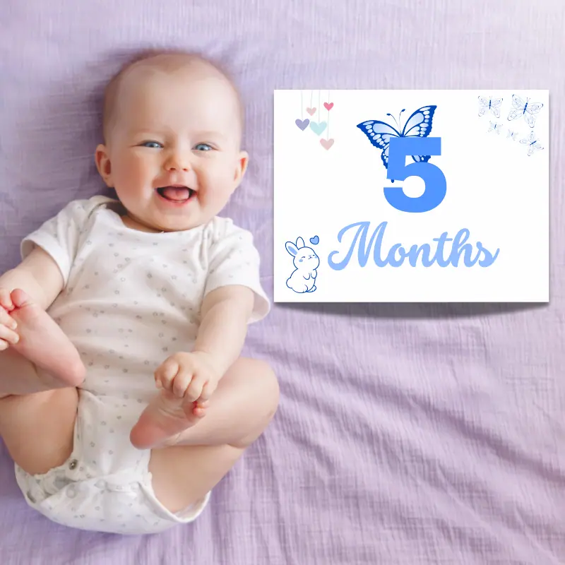 A laughing baby laying on a purple sheet with a milestone sign beside him that says 5 months and features butterflies and a bunny. The card is in complimentary shades of blue.