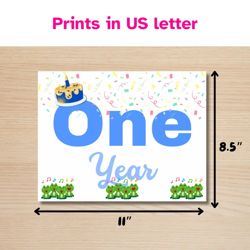 A baby milestone sign that says one year in complimentary shades of blue and features 12 singing frogs, a cake with one candle and confetti with lines beside it indicating it will print in 11 x 8.5 inches