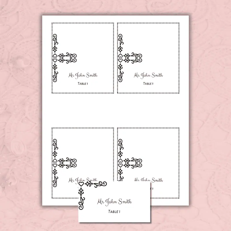 a folded and a flat wedding place card printable with a black decorative corner laying on a table.