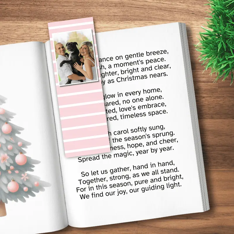 A photo bookmark with a photo of a couple and their dog on a pink stripe background laying in a book