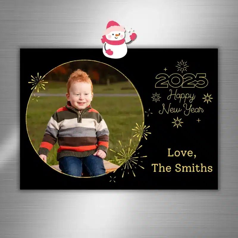 Happy New Year Photo card featuring golden fireworks and a happy toddler photo hanging on the fridge with a snowman magnet.