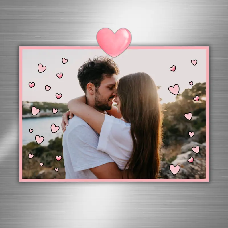 photo card with a happy couple surrounded by pink hearts hanging on the fridge with a pink heart magnet.